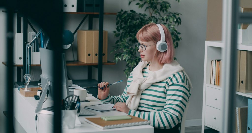 Commercial sédentaire avec casque téléphonique travaillant sur ordinateur dans un bureau moderne